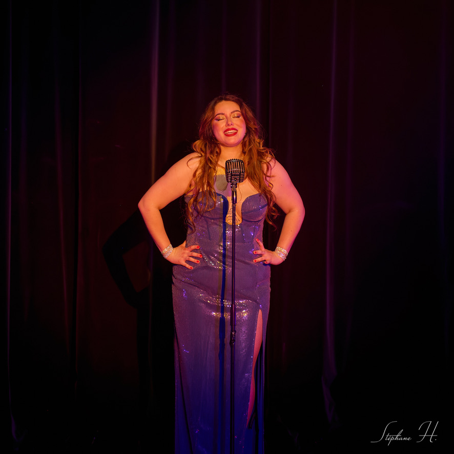 Woman singing in a blue shining dress.