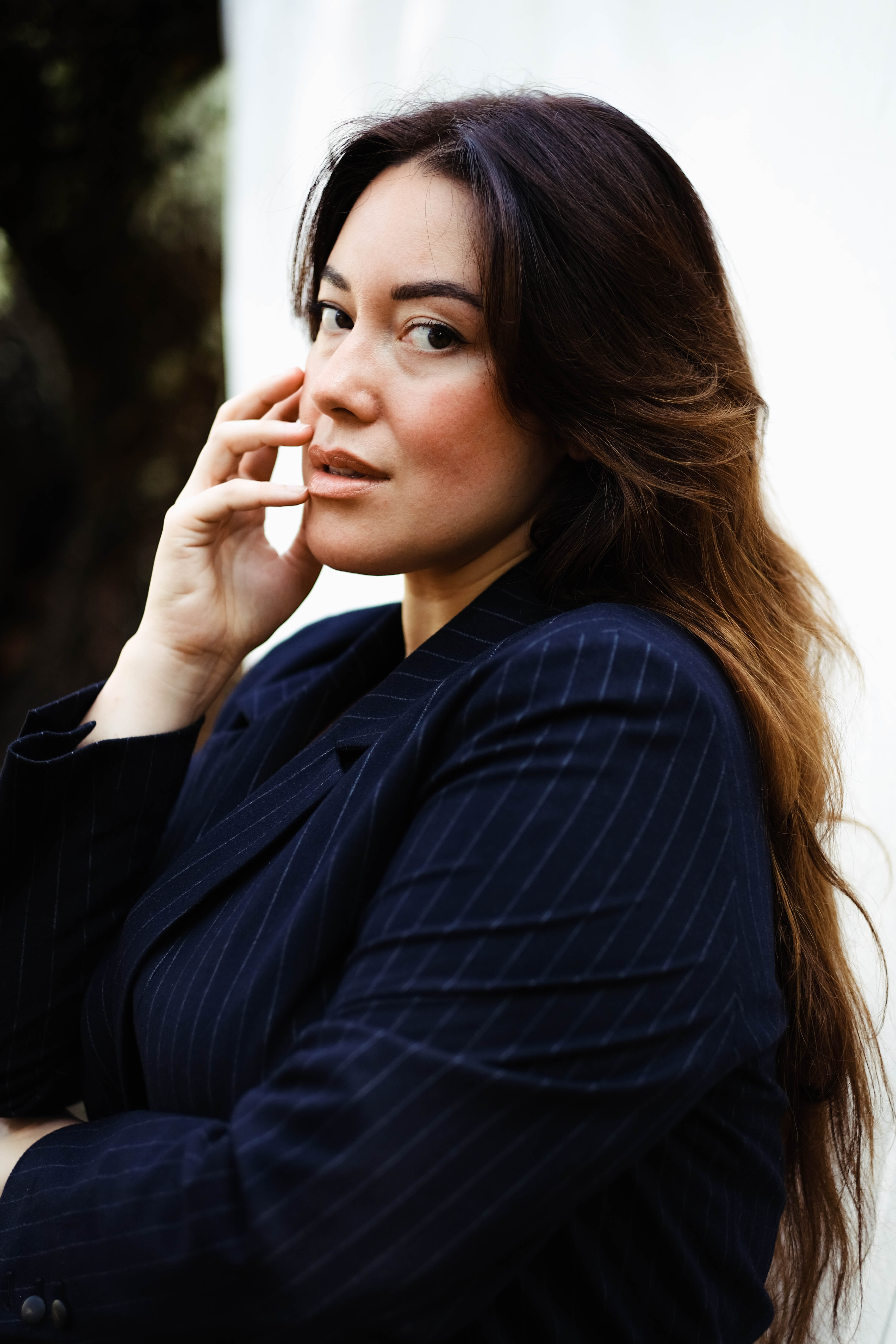 Profile of a woman wearing a blue stripped jacket.