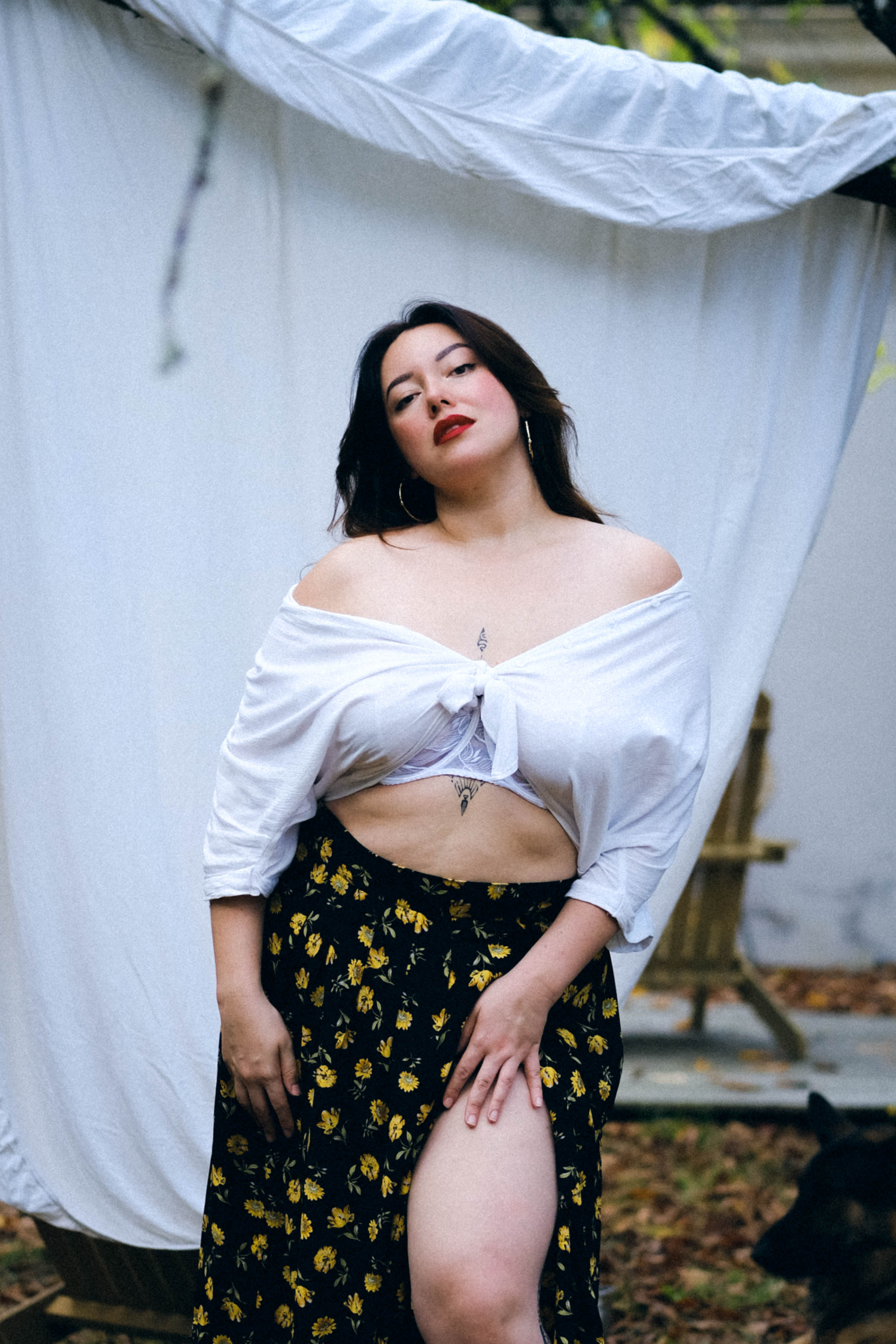 Woman wearing a white croc top and a black long flower imprinted skirt.