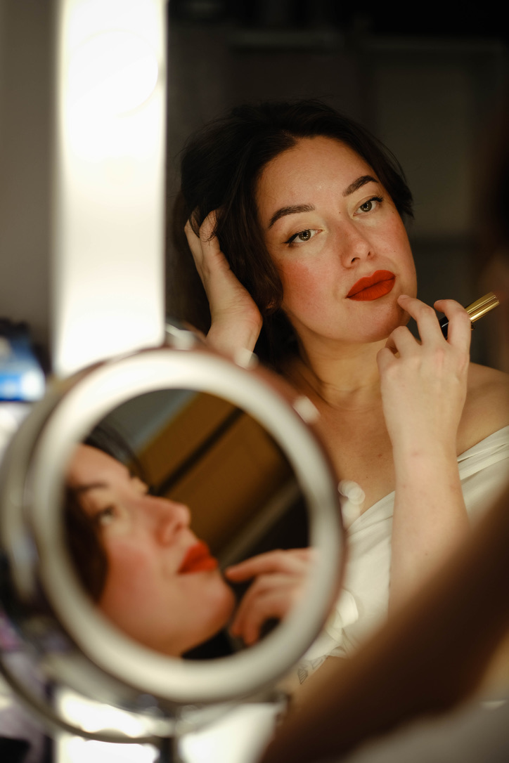 Woman reflection on a mirror after putting her lipstick.