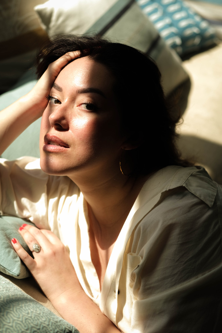 Close up of a woman with her face half hidden in a shadow.