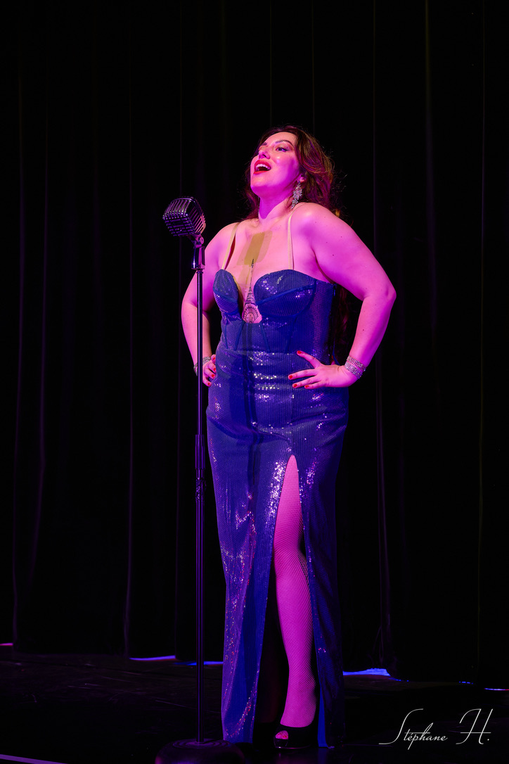 Woman singing in a blue shining dress.