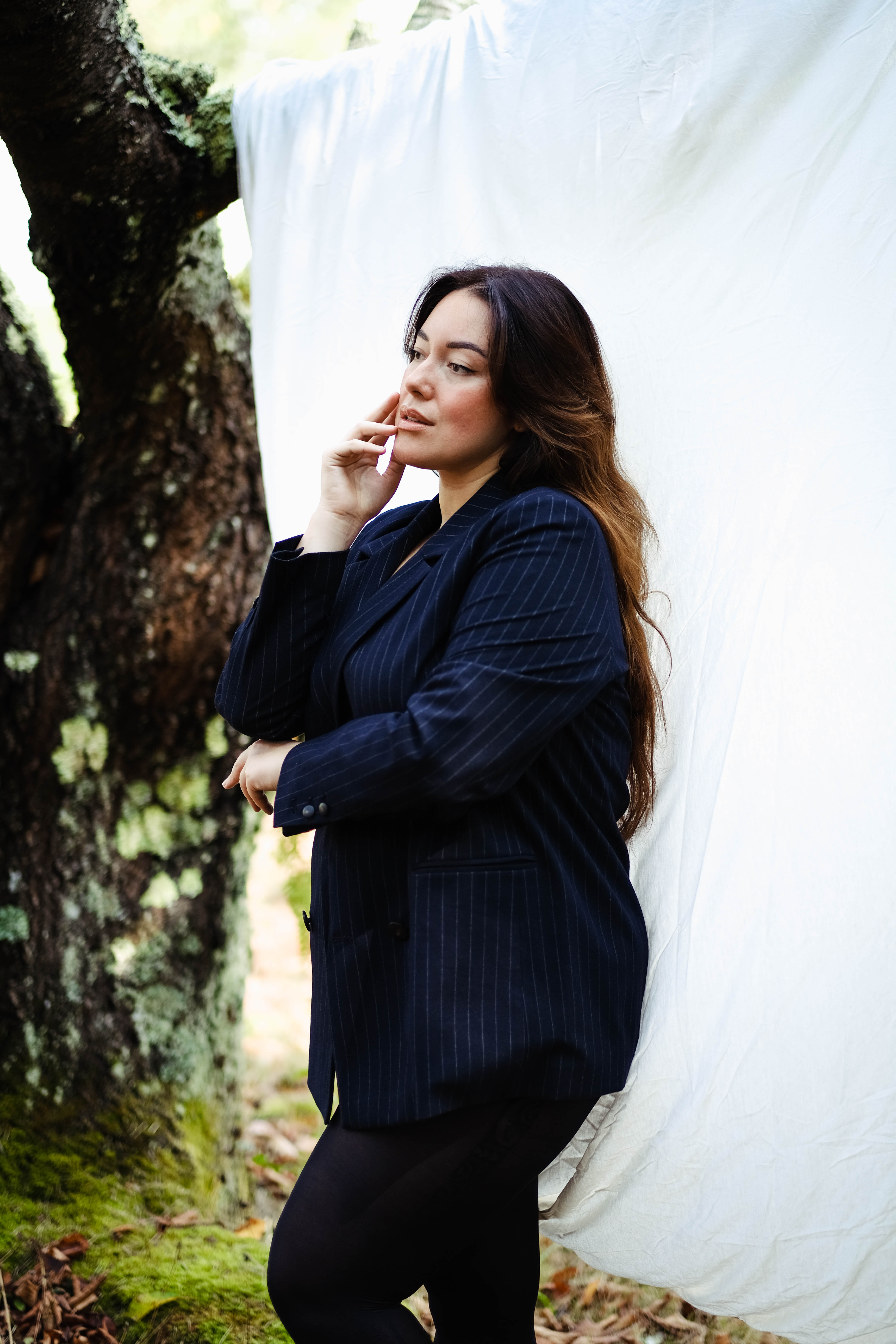 Profile of a woman wearing a blue stripped jacket.